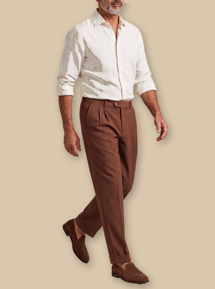 Roderick trousers in Brown, worn by a model on a warm sand studio background - Gentlemens Manor