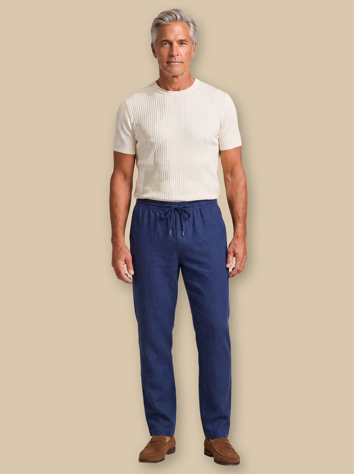 Roger trousers in Navy, worn by a model on a warm sand studio background - Gentlemens Manor