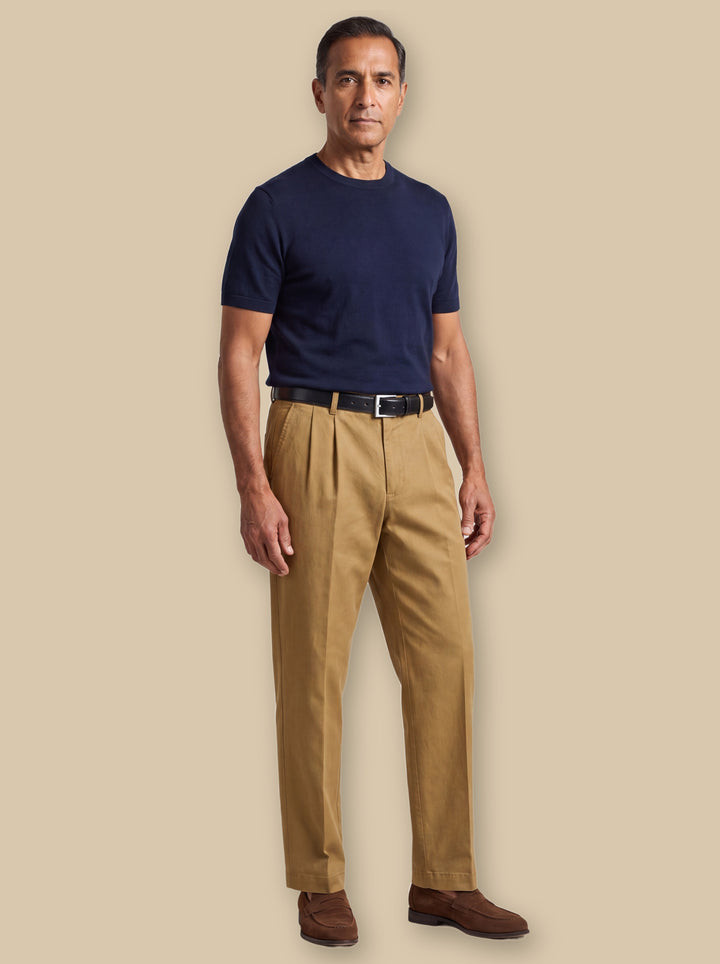Roland trousers in Sand, worn by a model on a warm sand studio background - Gentlemens Manor