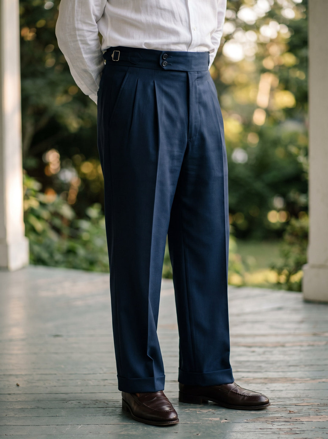 Roman trousers in Navy, worn by a model on a shaded garden veranda - Gentlemens Manor lifestyle