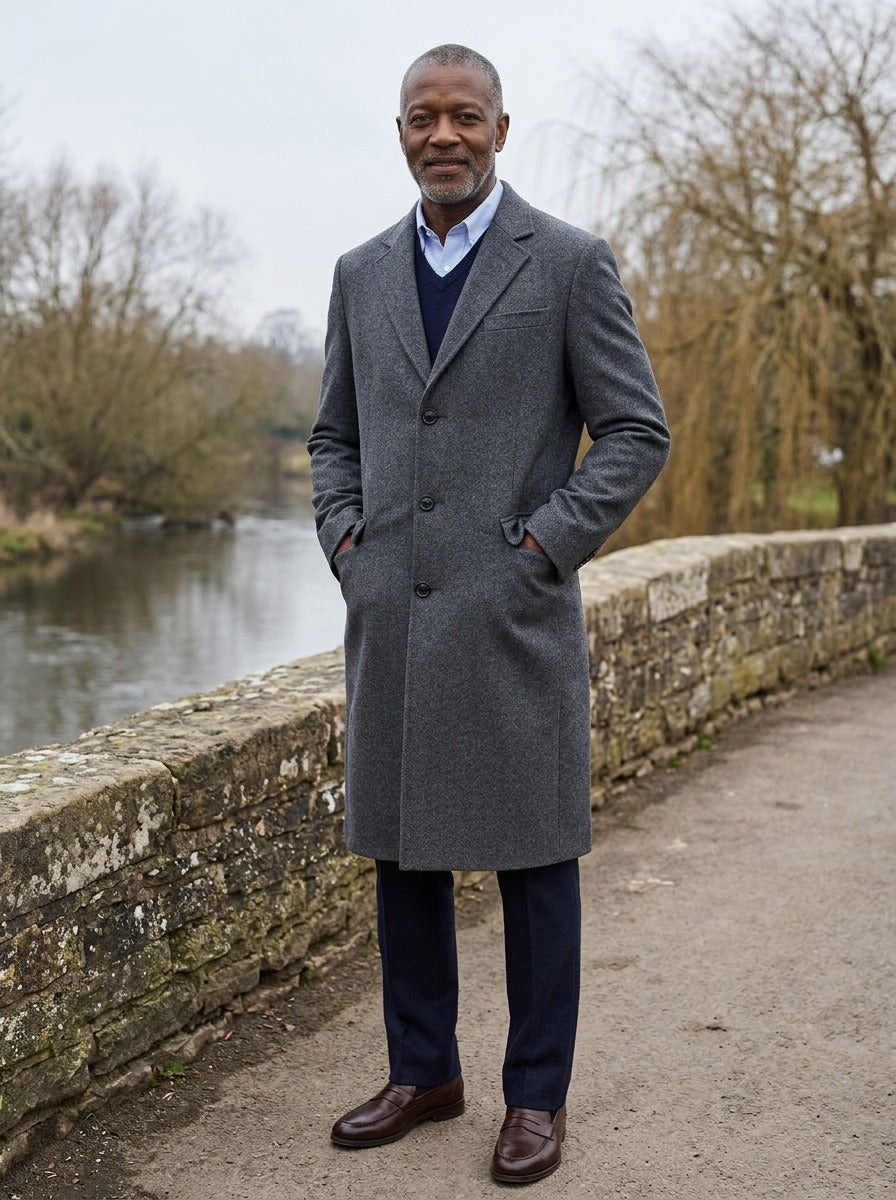 Stratford extra long quilted overcoat in Charcoal, lifestyle on a stone footbridge, Gentlemens Manor
