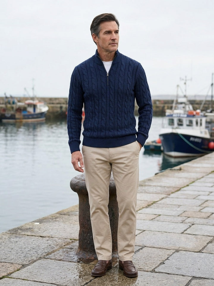 Sutherland cable knit quarter zip sweater in Navy, lifestyle on a stone harbor quay, Gentlemens Manor