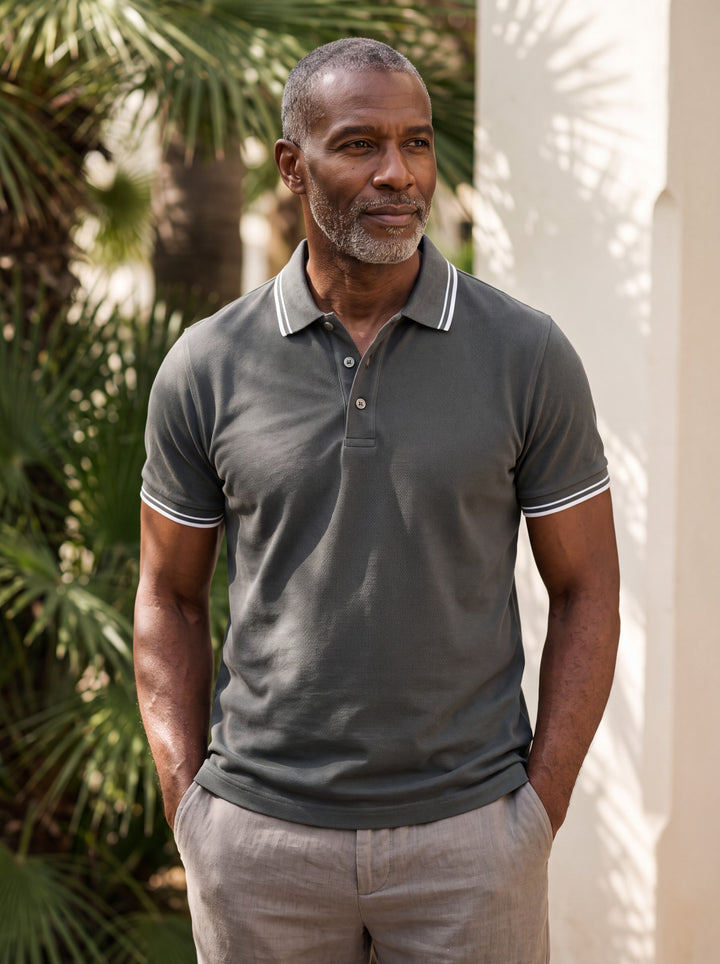 Walter Men polo shirt in charcoal, worn by a model on a Mediterranean terrace - Gentlemens Manor lifestyle