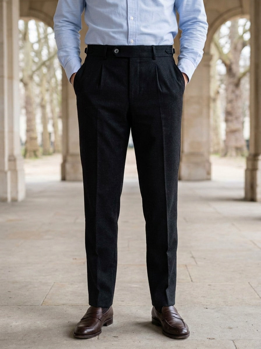 Warwick brushed pleated tapered trousers in Black, lifestyle in a stone colonnade, Gentlemens Manor