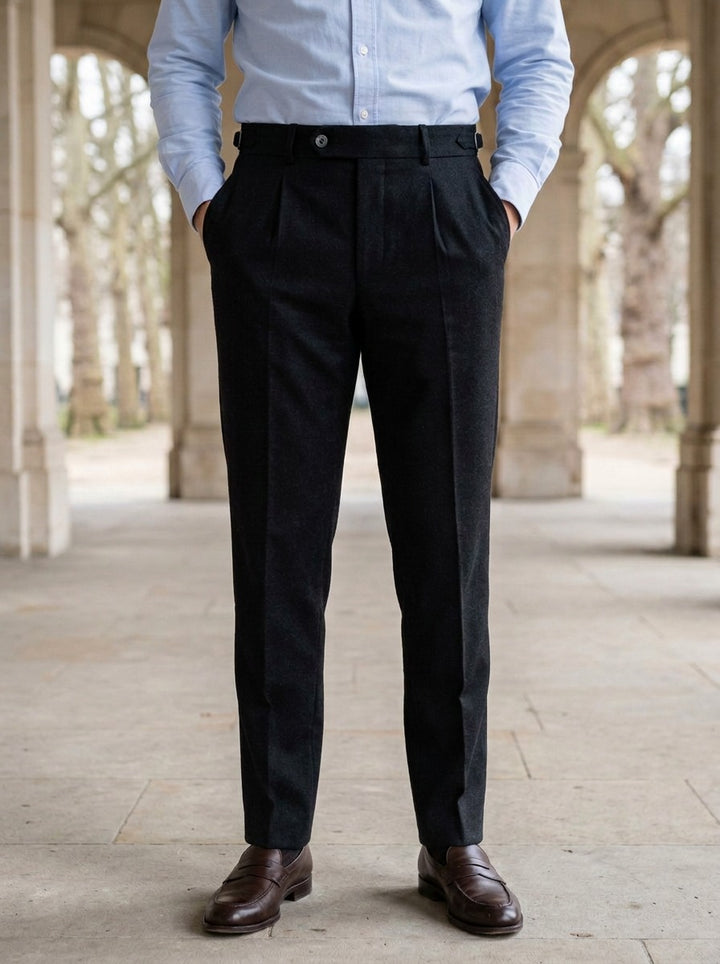 Warwick brushed pleated tapered trousers in Black, lifestyle in a stone colonnade, Gentlemens Manor