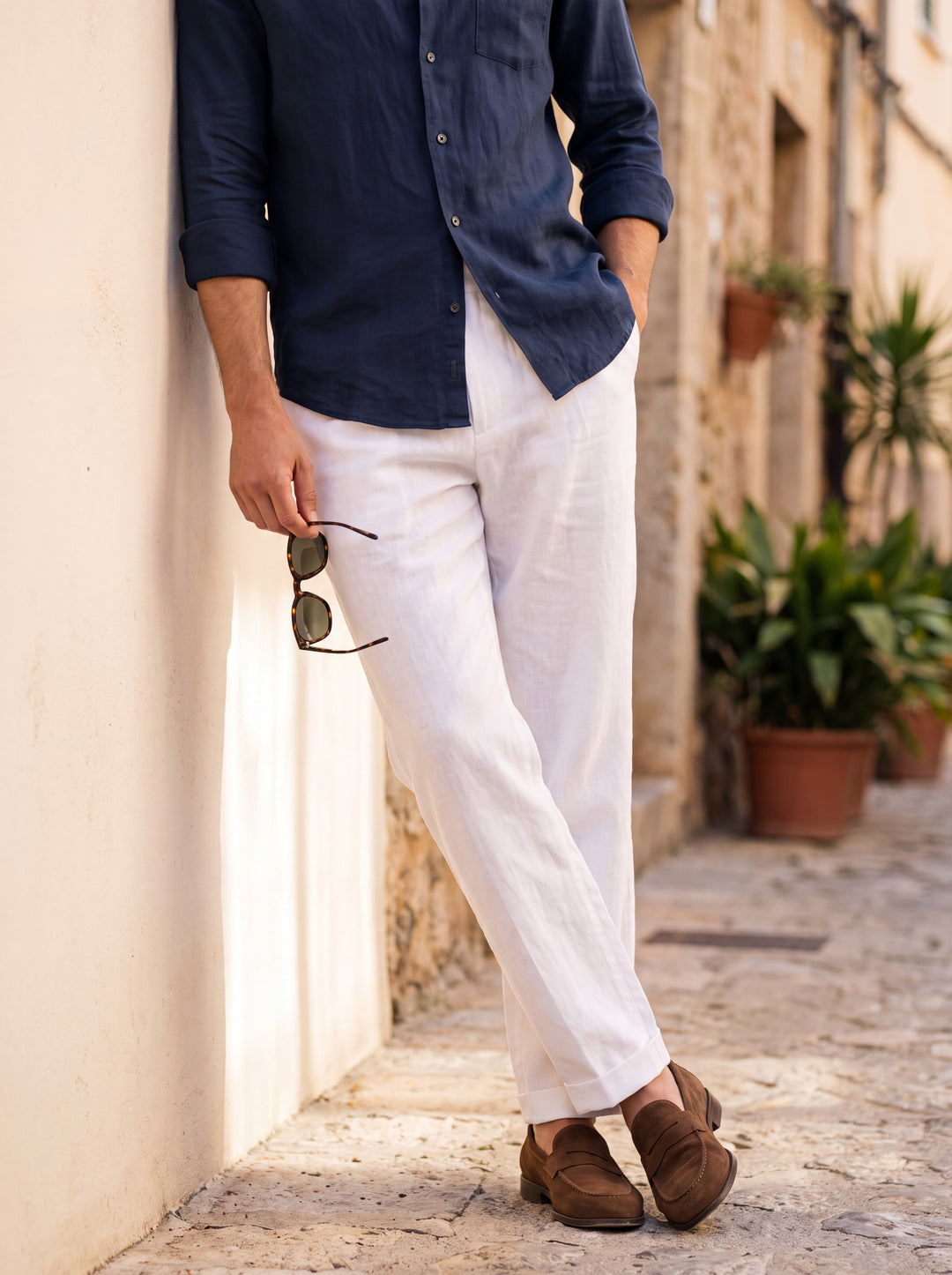 Whitfield Men trousers in white, worn by a model on a Mediterranean terrace - Gentlemens Manor lifestyle
