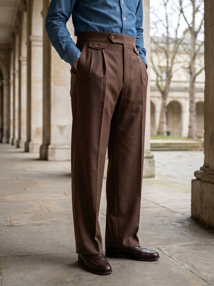 Whitley wide leg pleat tab trousers in Brown, lifestyle in a stone colonnade, Gentlemens Manor
